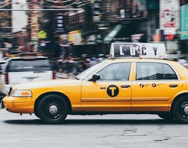 yellow taxi on concrete road