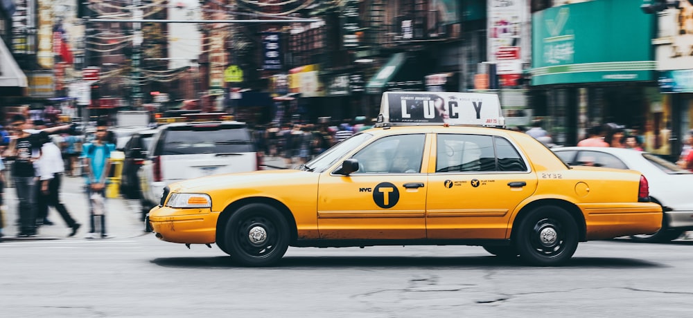 Taxi jaune sur route bétonnée