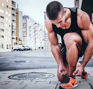 man tying his shoes getting ready to run like a immortal runner