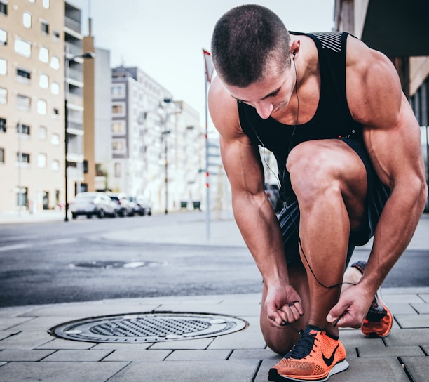 man tying his shoes getting ready to run like a immortal runner