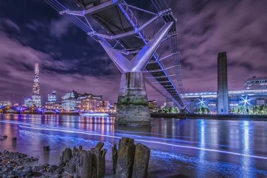 bridge over the river connected to city at night time in Millennium Bridge United Kingdom