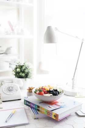 A warm, inviting office desk with a phone, notebook, and a small bowl of colorful Indian spices.
