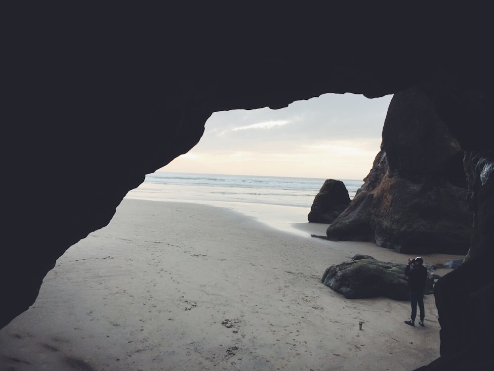 Persona que toma una foto al lado de la cueva