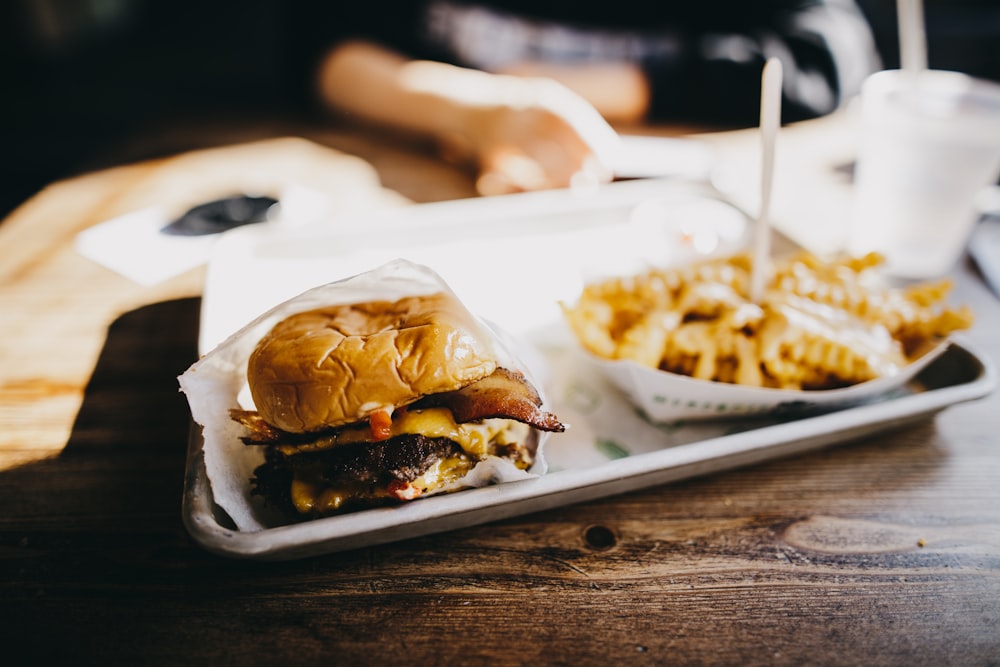 macro photography of burger and fries served on tray