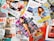 A variety of colorful magazines are scattered, featuring fashion models on the covers. Text in different languages and fonts highlights themes like fashion, beauty, and lifestyle.
