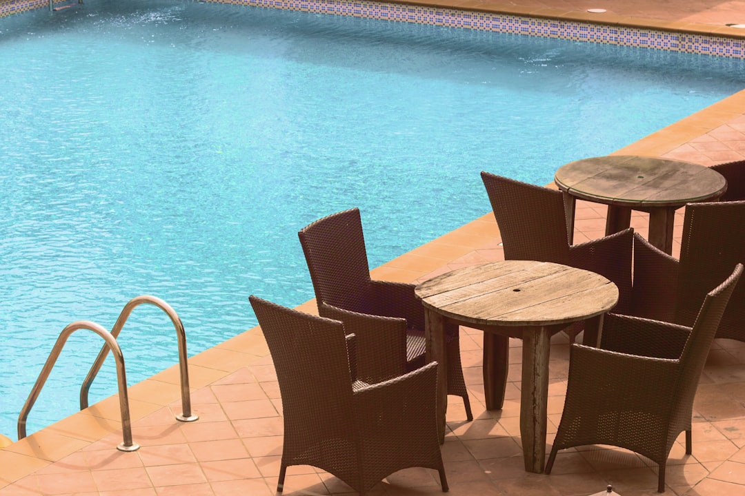 wooden cafe table and chairs beside inground pool, Chill out. It’s morning
