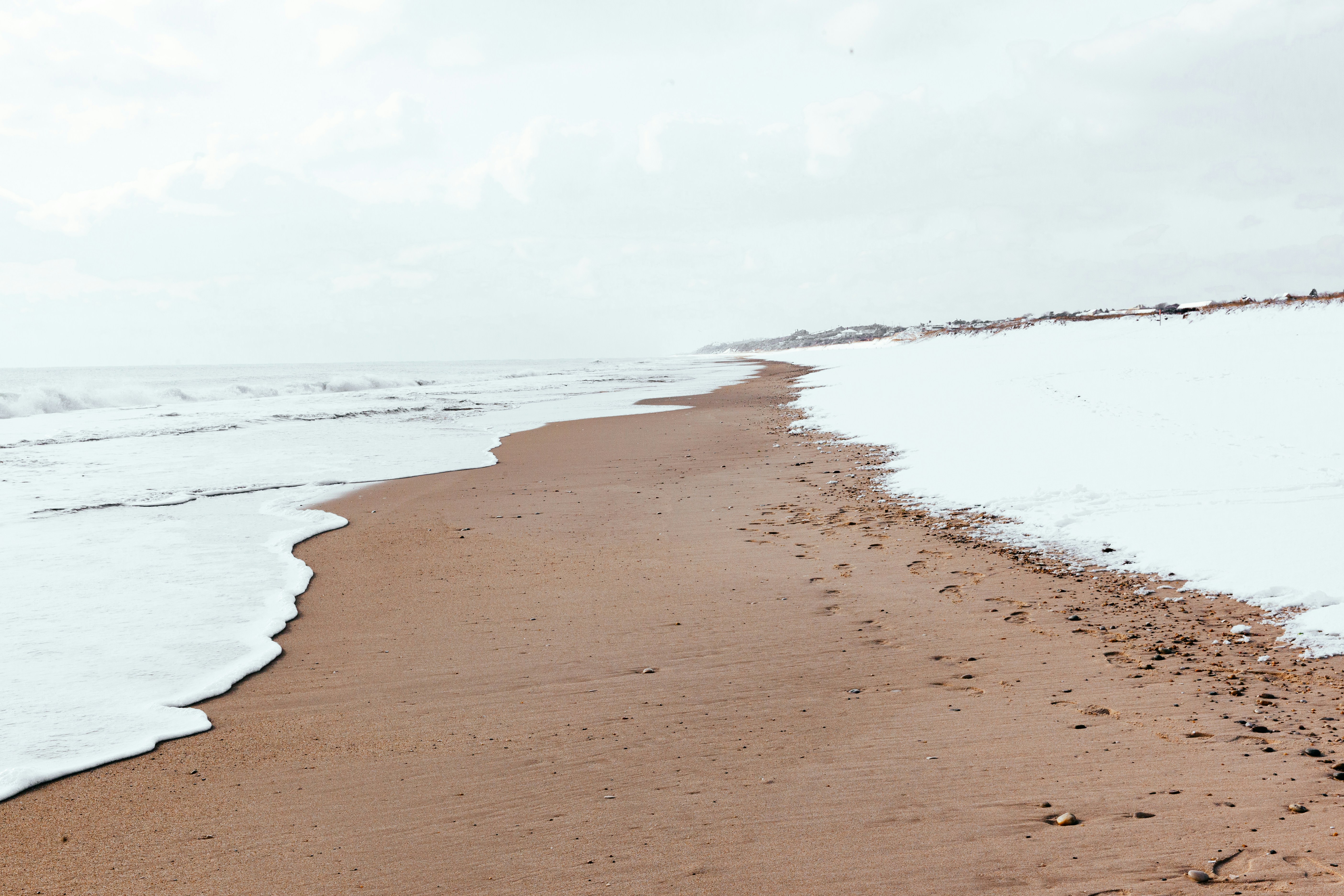 brown sand near body of water during daytime