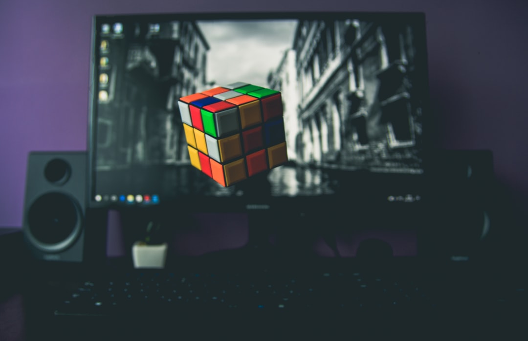 turned on flat screen computer monitor displaying 3x3 Rubik's cube
