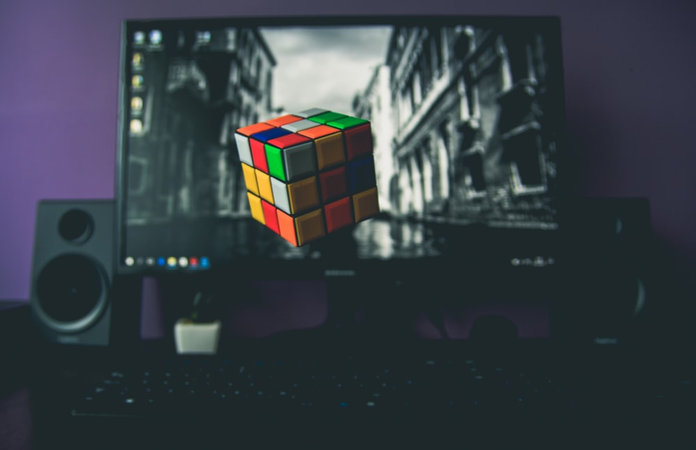 turned on flat screen computer monitor displaying 3x3 Rubik's cube