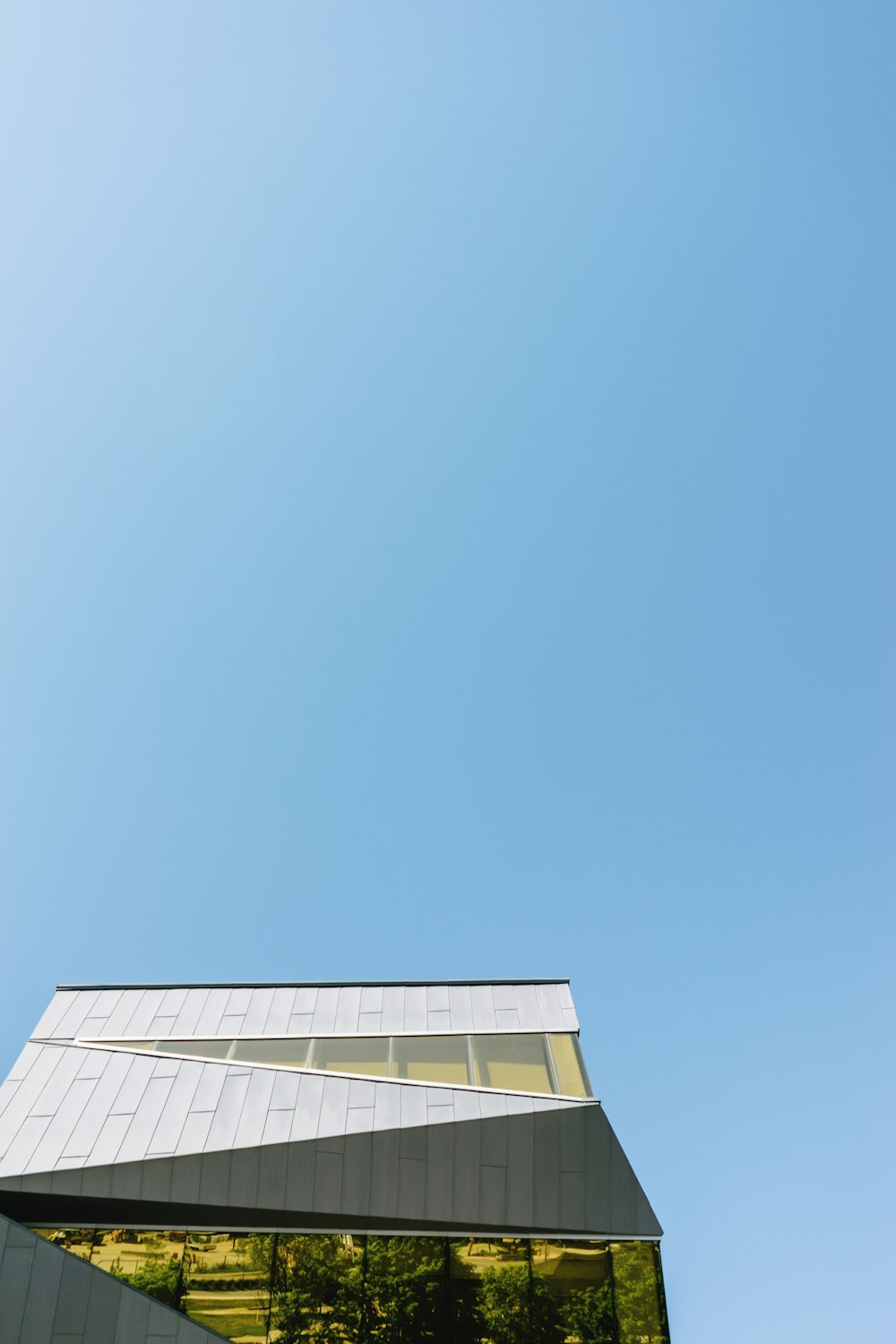 澄み切った青空の下での白いコンクリートの建物のローアングル撮影