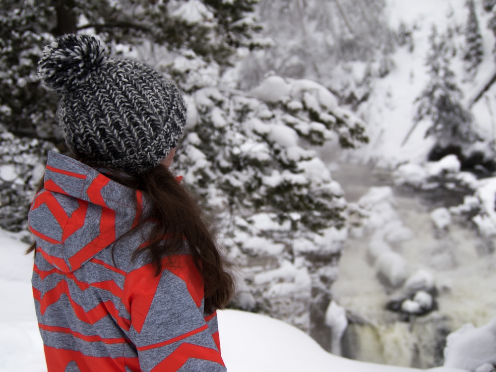 Frau steht auf Schneefeld in der Nähe von Bäumen