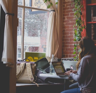 woman using computer sitting on black chair