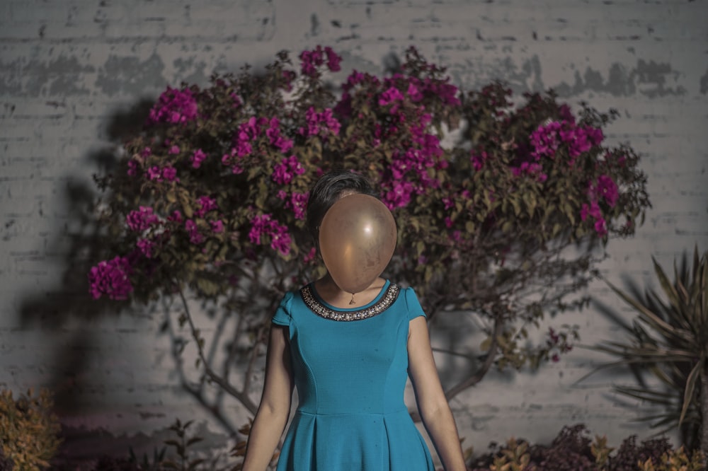 femme debout devant un ballon brun