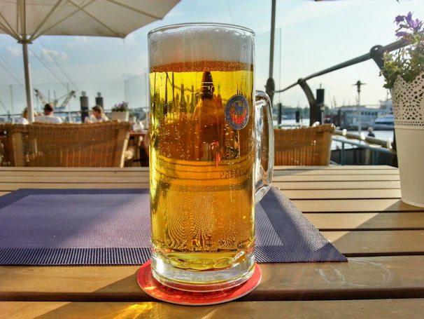 A cold glass of Maré Viva’s signature craft beer beside a seafood platter on an outdoor patio