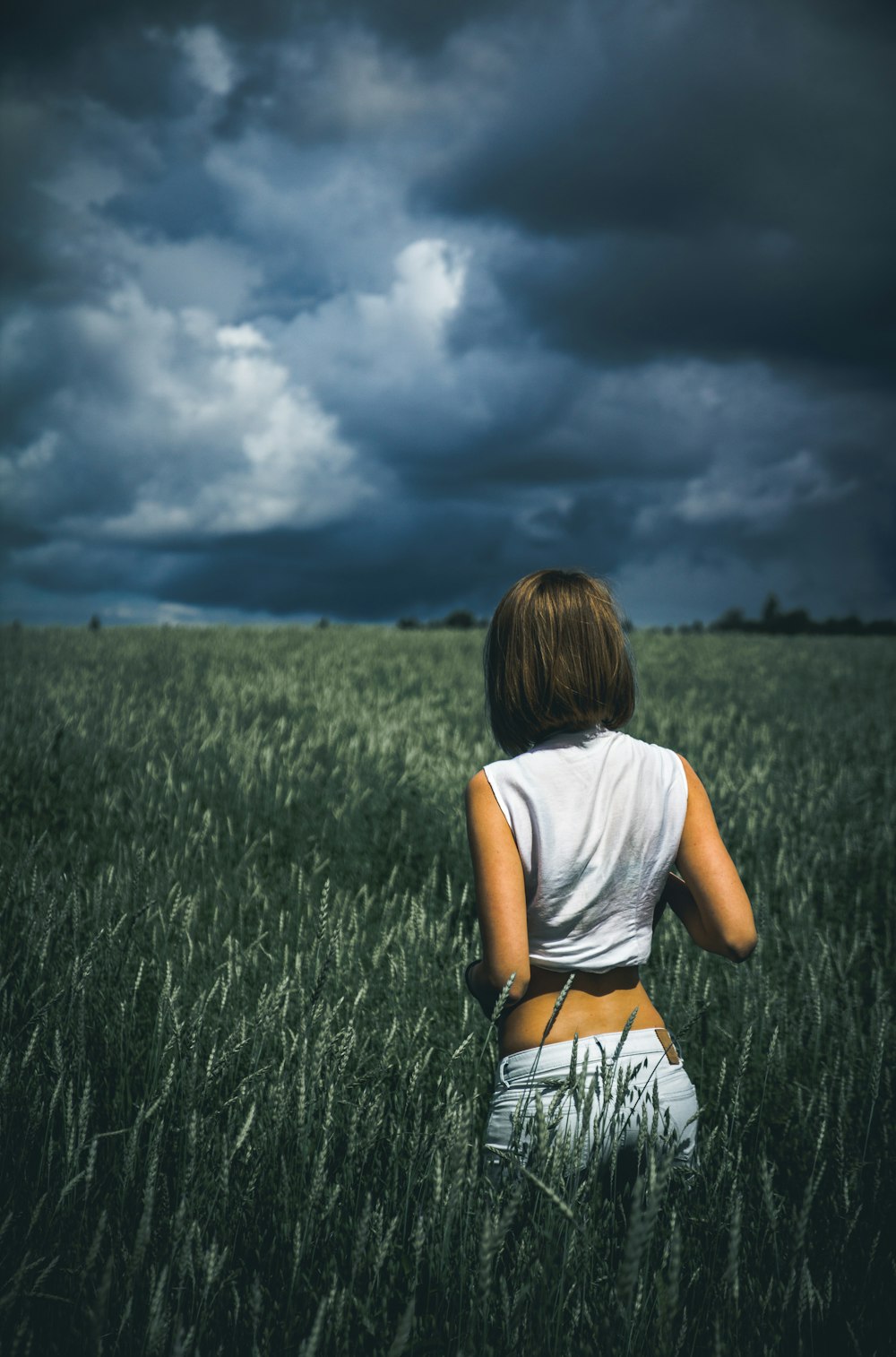 femme en haut sans manches sur le champ de plantes