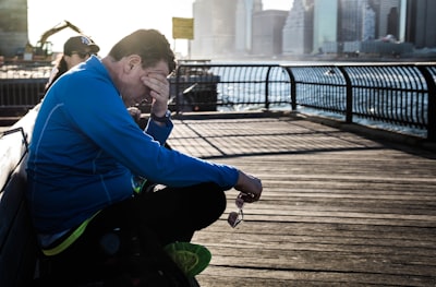 man sitting on bench beside woman tired teams background