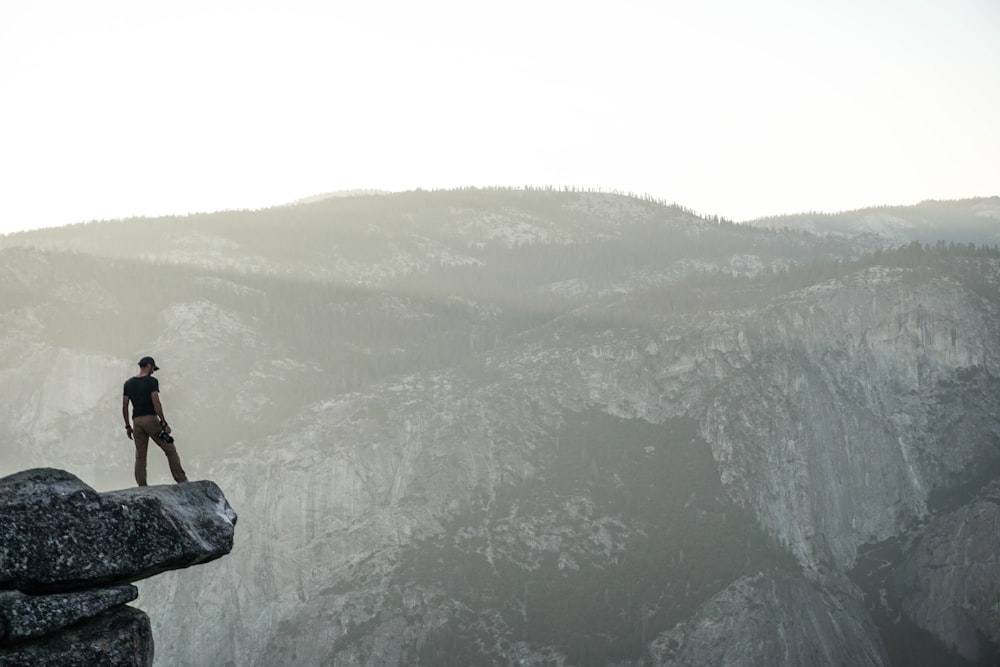 person standing near rock cliff