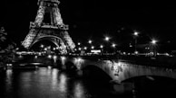 Night view of the Seine river with reflections of city lights and bridges.