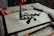 Close-up of hands skillfully creating traditional Chinese ink painting on rice paper.