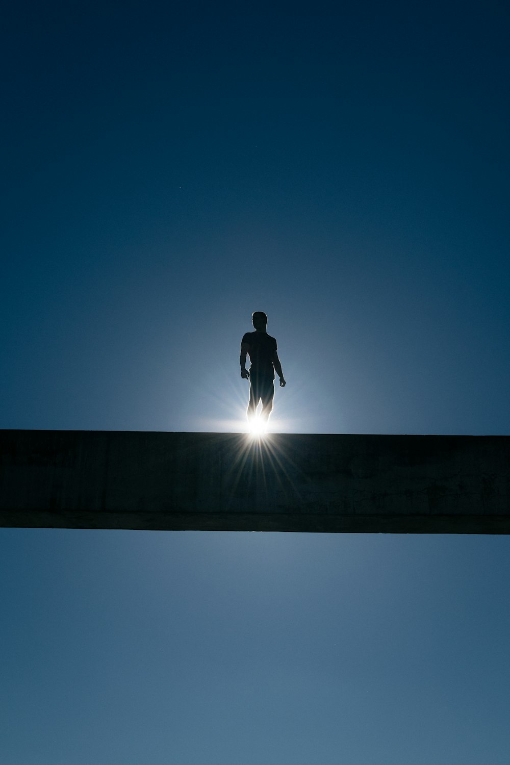 Silhouette eines Mannes, der auf der Brücke steht