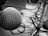 A close-up view of a silver microphone with a mesh grille, prominently featured on the left side of the image. The background includes tangled audio cables and a microphone stand, all in black and white.