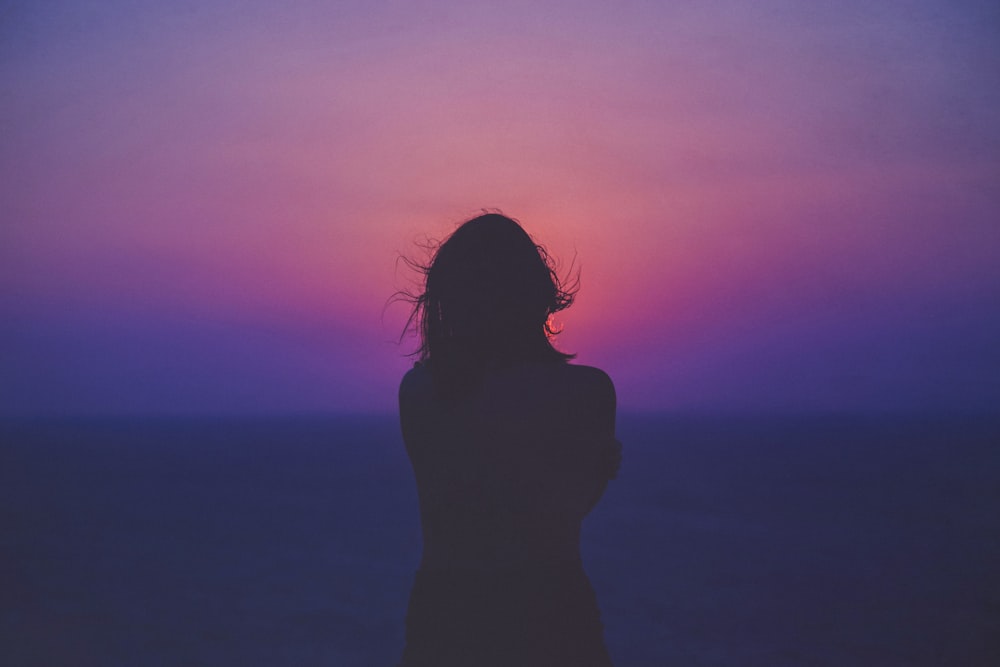 silhouette of a woman with pink and purple sky