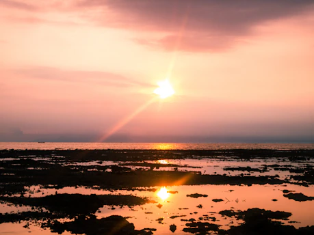 A serene sunset over a luxurious Balearic coastline with golden hues reflecting on the water.