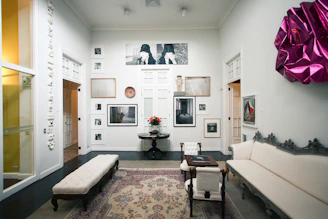 A cozy room featuring several metal art prints hanging seamlessly on the wall with magnets, showcasing colorful digital designs.