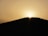 A group of trekkers walking through the golden dunes of the Sahara at sunset.