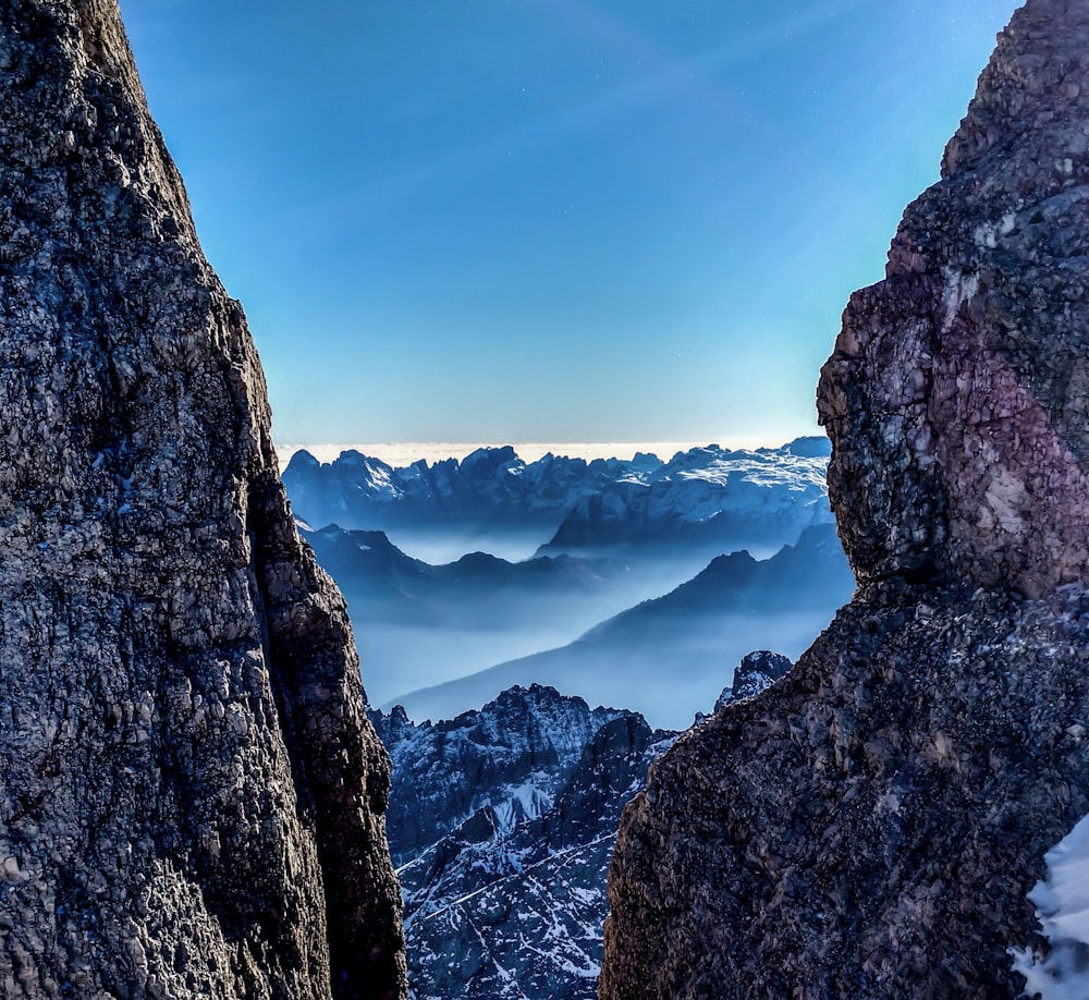 rock mountains with mist in between rock canyon view during daytime