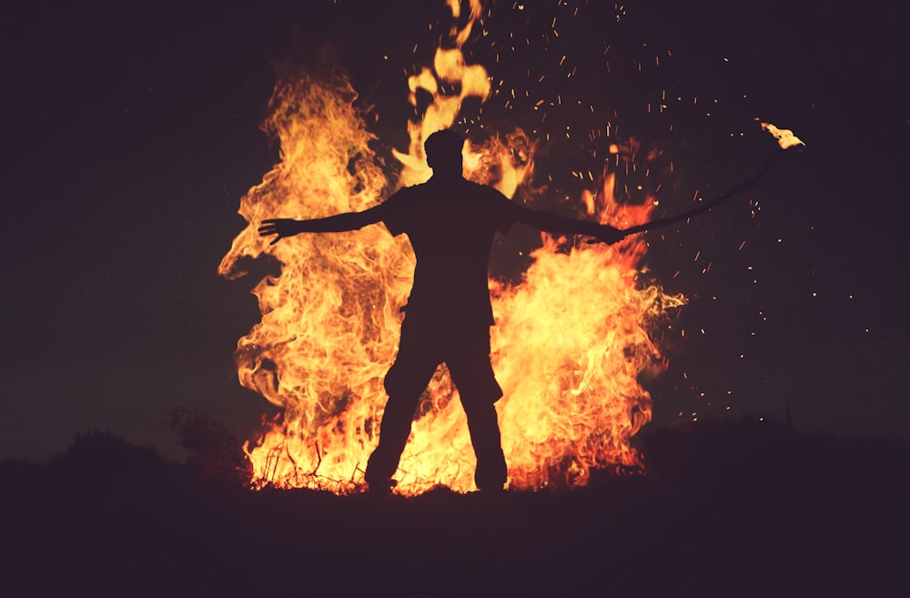 personne debout devant le feu pendant la nuit