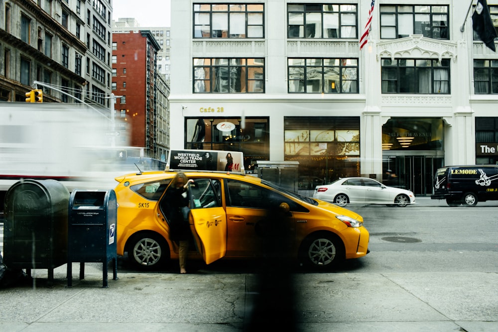 woman going inside yellow car