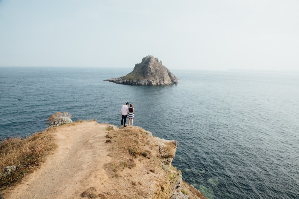 aerial photography of man and woman near cliff