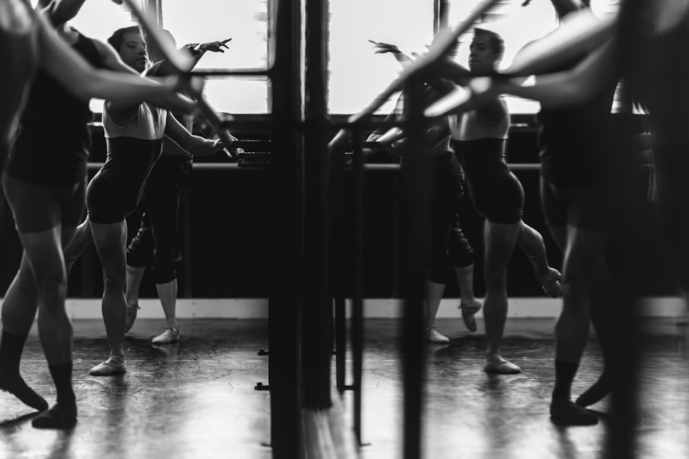 grayscale photo of womens exercising in front of mirror