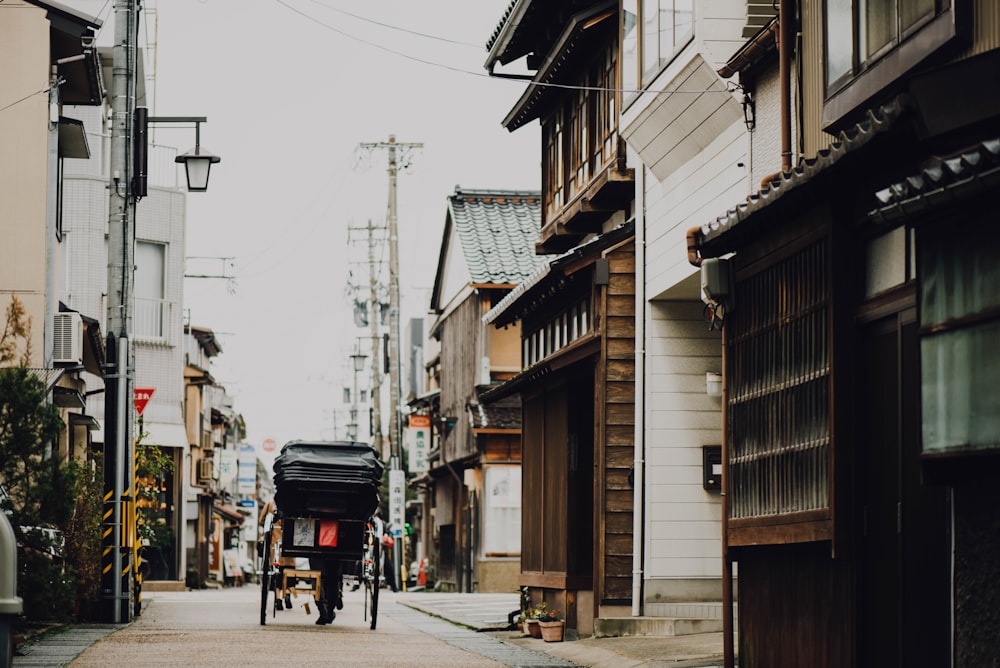 black carriage passing through buildings