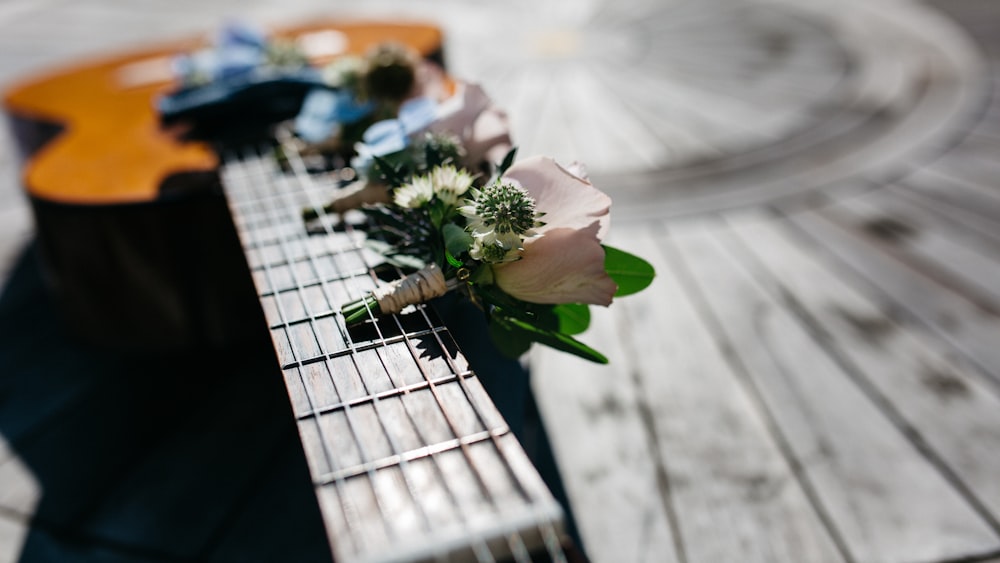 A blurry shot of an acoustic guitar with tiny bouquets of flowers on its neck