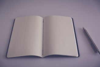 A minimalist notebook open with a pen resting, ready for new ideas.