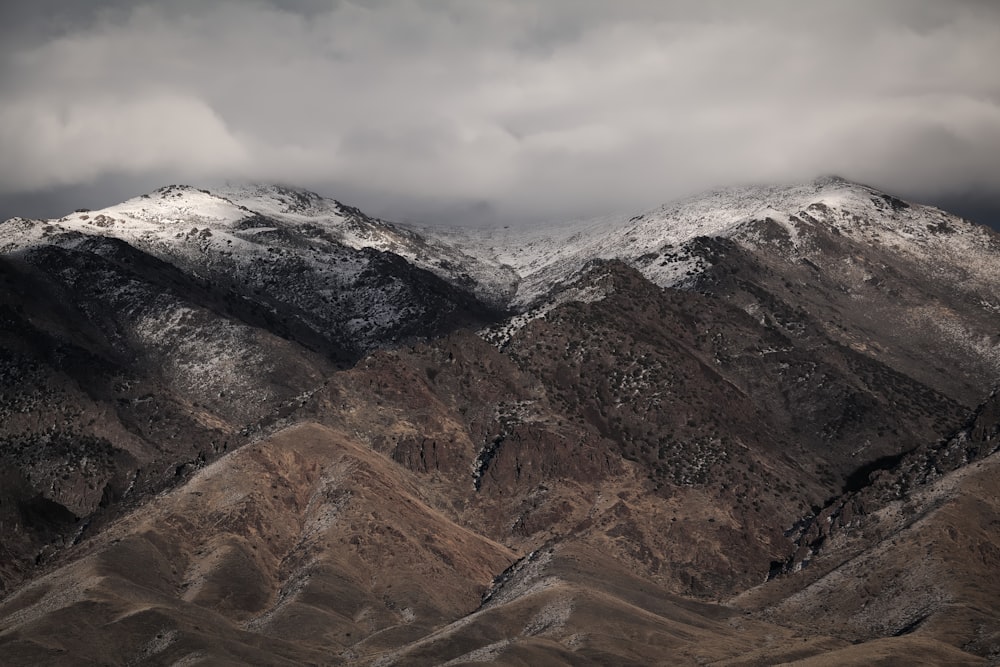 Montanhas marrons e pretas sob céu nublado