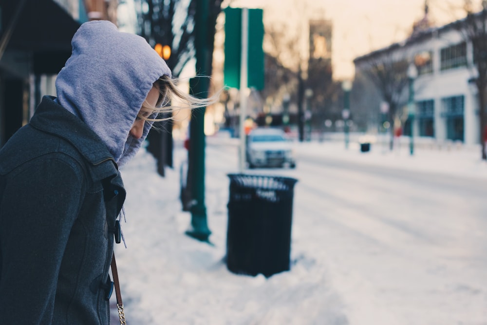 selective focus photography of person in black hooded coat