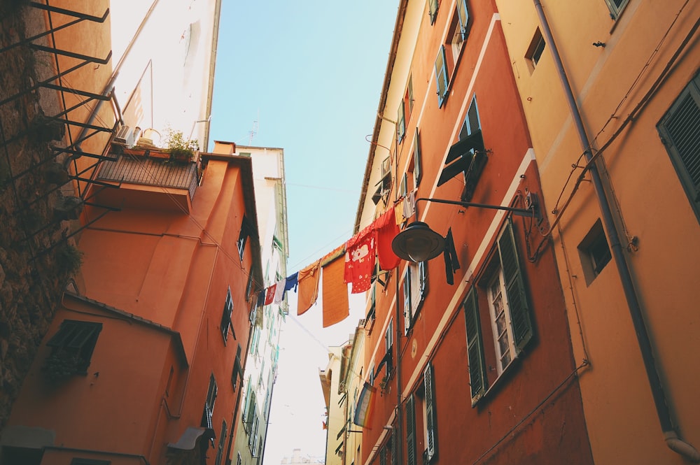 assorted-color textiles hanged on clothes dryer in between houses