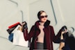 photo of woman holding white and black paper bags