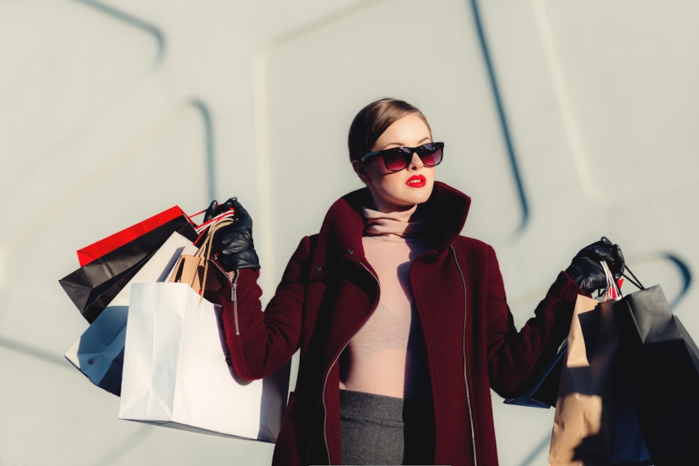 photo of woman holding white and black paper bags