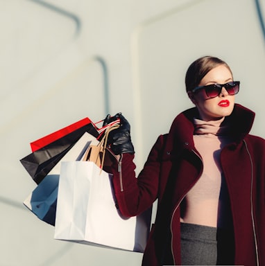 photo of woman holding white and black paper bags