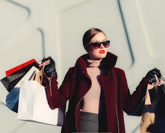 photo of woman holding white and black paper bags