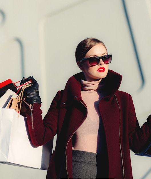 photo of woman holding white and black paper bags