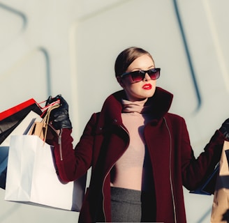 photo of woman holding white and black paper bags