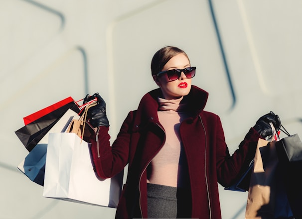 photo of woman holding white and black paper bags