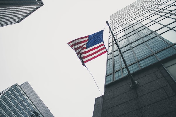 A low angle view of a skyscraper with an American flag protruding.