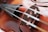 A close-up of a violin being carefully repaired by a technician.