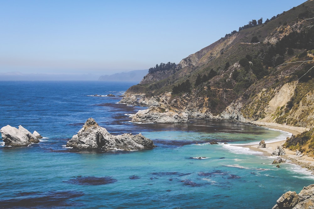 brown mountain near seawater